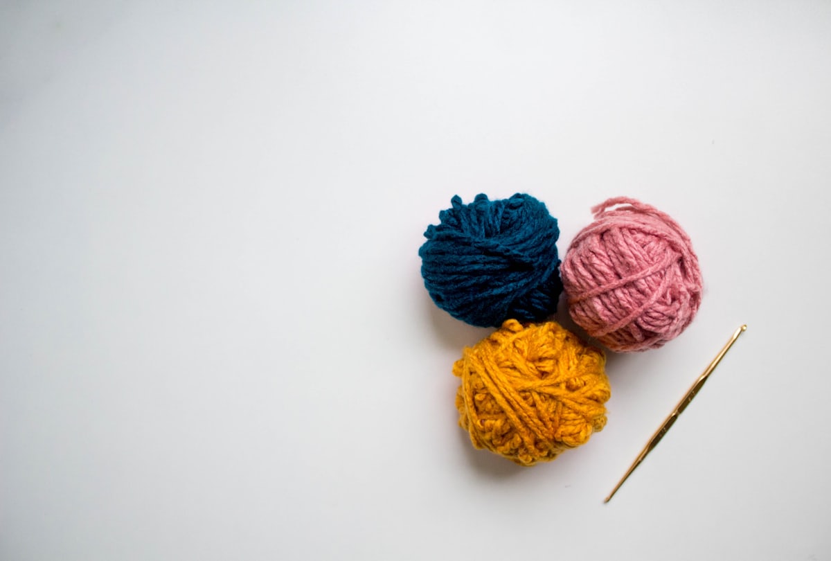 Blue and red crochet yarn arranged on a light surface